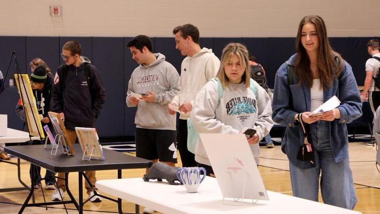 Attendees view some of the artwork submitted at the annual campus and community art show, hosted by the IDREAM Team at Penn State DuBois.